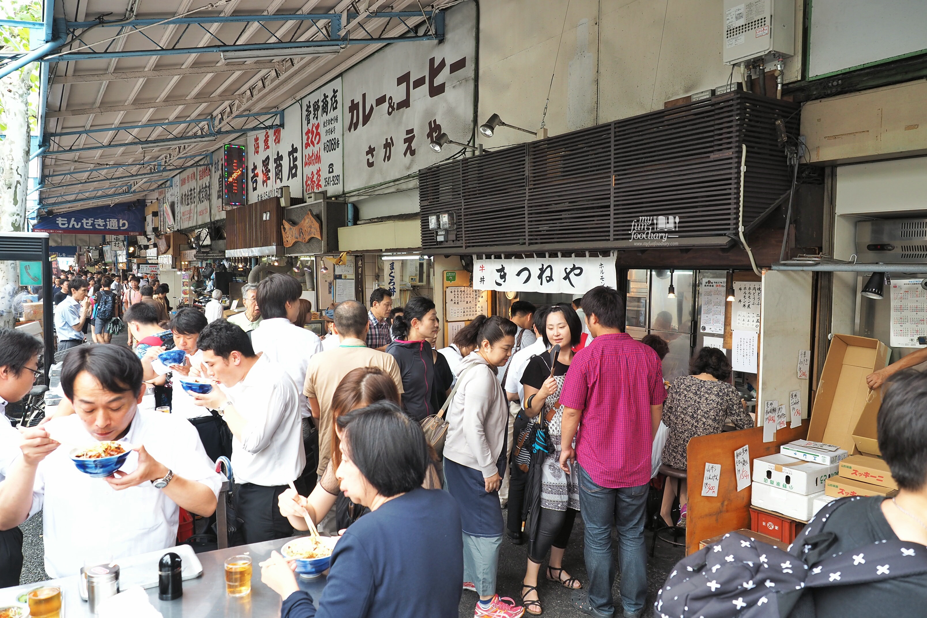 The way people enjoying some food from the food stall at Tsukiji Market by Myfunfoodiary